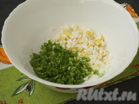 Отложить один варёный яичный желток, оставшиеся яйца нарезать кубиками. Измельчить зелёный лук, горсть отложить.