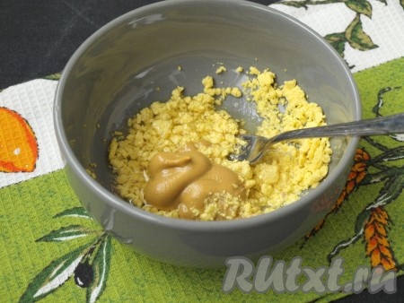 Для приготовления заправки в пиале размять яичный желток, который мы откладывали, добавить масло из рыбных консервов, горчицу и черный молотый перец. Если горчица достаточно острая, то перец можно не добавлять. Я использовала "Казацкую" горчицу. Заправку хорошо размешать.