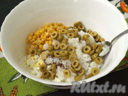 Добавить в салат рис и нарезанные кружочками оливки.
