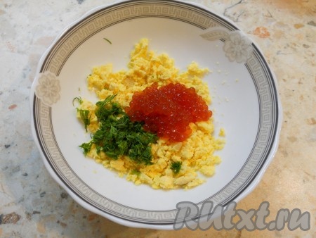 К измельченным желткам и укропу выложить красную икру.
