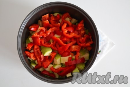 Перец вымыть, удалить семена и плодоножку, нарезать соломкой и выложить к другим овощам и куриным голеням в чашу мультиварки.
