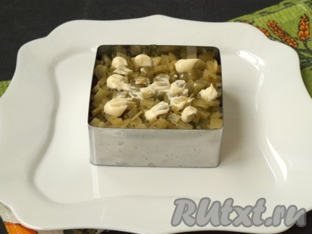 Огурцы, нарезанные небольшими кубиками, выложить сверху лука. Если готовить в салатнике, то огурцы можно натереть на крупной тёрке и отжать от лишней влаги. На огурцы нанести майонез.