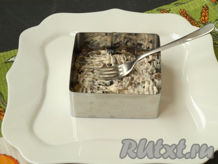 Салат "Грибы под шубой" формируется слоями. Я формировала с помощью формочки, поставив её на плоскую тарелку, можно формировать и в салатнике. На плоскую тарелку нужно поставить формочку, выложить первым слоем жареные грибы с луком (несколько жареных грибочков я отложила для украшения), немного смазать майонезом, разровнять, утрамбовать вилкой.