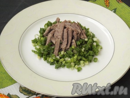 Говядину нарезать соломкой. Зелёный лук измельчить. В центр большого блюда горкой выложить мясо, вокруг разместить зелёный лук.
