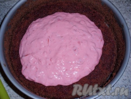 Выложить один шоколадный корж на блюдо, закрепить бока разъемной формы для выпечки, пропитать корж вишневым соком, затем выложить половину вишневого крема.&nbsp; Всё тоже самое повторить со вторым коржом. Сверху поместить третий корж.