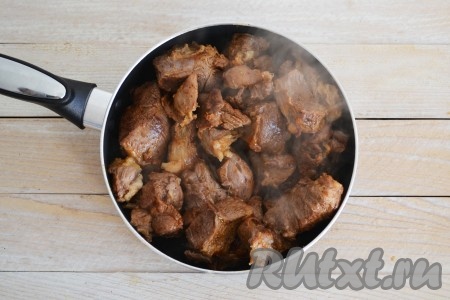 Первые 2-3 минуты обжарить баранину со всех сторон на сильном огне, затем приубавить огонь к среднему (это нужно для того, чтобы кусочки припеклись, а сок остался внутри, тогда баранина останется сочной) и продолжать готовить, периодически перемешивая, пока не уйдет вся образовавшаяся жидкость, а мясо не приобретет красивый, румяный цвет. На это понадобится 25-35 минут. Добавить измельченные зубчики чеснока и, по желанию, нарезанный острый перец.
