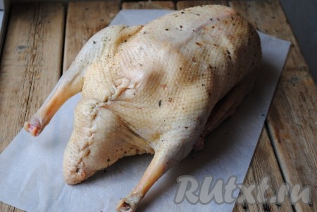 Зашить брюшко гуся, фаршированного яблоками и черносливом, ниткой или закрепить зубочистками. Выложить птицу на противень и запекать в разогретой духовке при температуре 180 градусов около 2 часов. Время запекания зависит от Вашей духовки, возраста и веса птицы. Во время запекания нужно периодически поливать гуся образовавшимся соком, это нужно для того, чтобы птица приобрела красивый румяный цвет и хрустящую корочку. За 5 минут до готовности гуся, натереть его выдавленным через пресс чесноком.&nbsp;
