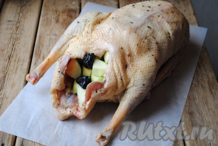 Выложить внутрь гуся подготовленную начинку.
