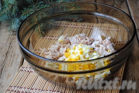 Яйца отварить вкрутую, очистить, нарезать кубиками и выложить к нарезанному куриному мясу. 