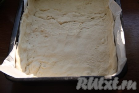 Форму для выпечки застелить бумагой для выпечки и распределить по дну формы слоеное тесто. Вилкой наколоть поверхность теста и отправить в разогретую духовку запекаться при температуре 180 градусов на 15 минут.