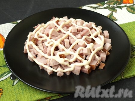 Яйца заранее отварить в течение 10 минут с момента закипания воды, остудить и очистить. Ветчину, нарезанную кубиками, выложить на плоскую тарелку, смазать майонезом.