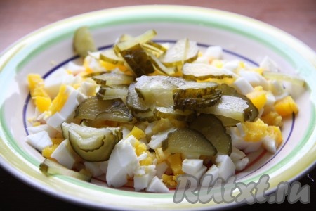 Огурчики нарезать слайсами или кубиками и выложить к яйцам.
