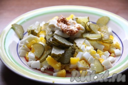 Добавить к яйцам и огурцам майонез, горчицу и черный молотый перец по вкусу, перемешать.
