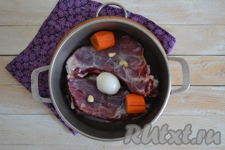 Очистить лук, морковь и чеснок. Крупные овощи разрезать на 2-4 части и выложить в кастрюлю.