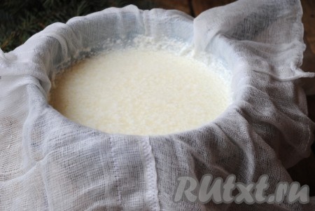 Снять кастрюлю с огня и оставить на 10-15 минут для остывания. Затем дуршлаг застелить несколькими слоями марли и вылить молочную массу. 