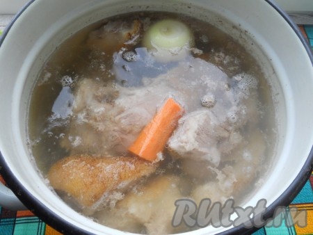 Поставить кастрюлю на огонь, довести содержимое до кипения, убрать пену. Поместить в кастрюлю целую луковицу и морковь. Бульон посолить по вкусу.
