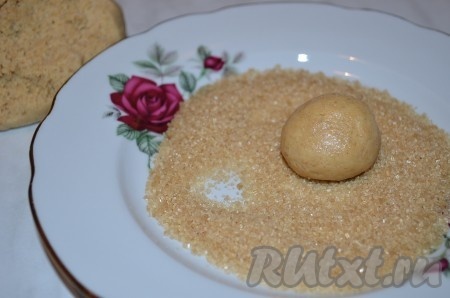 Тесто для имбирного печенья с корицей получается мягким и липнущим к рукам. Накрыть его плёнкой и поставить в холодильник минимум на 1 час. Затем присыпать руки мукой и скатать из теста шарики величиной с грецкий орех. Обкатать в сахаре.
