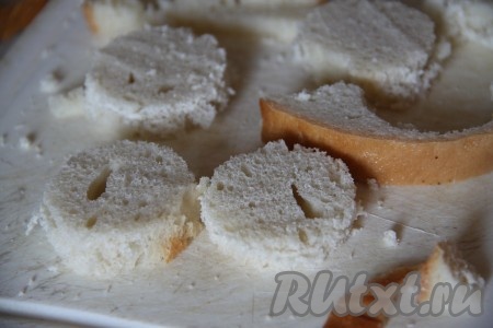 Батон нарезаем тонкими ломтиками и с помощью рюмки выдавливаем кружочки.