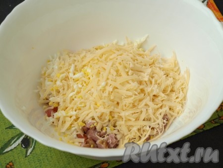 Очищенные яйца, сваренные вкрутую, и сыр натереть на крупной тёрке и выложить в салат к ветчине и помидорам.