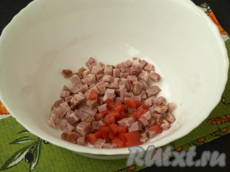 Ветчину нарезать кубиками и поместить в миску. Помидор, отделив от сочной мякоти, нарезать кубиками и добавить в миску с ветчиной.