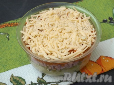 Полоски корейской моркови нарезать на более короткие полоски. Если вы будете готовить с варёной морковкой, тогда её нужно очистить, натереть на крупной тёрке. Выложить равномерно корейскую (или варёную) морковь поверх ветчины, смазывать майонезом не надо. Следующим слоем выложить сыр, натёртый на крупной тёрке. Прижать сыр рукой. Накрыть слой сыра плёнкой, свисающей с краёв миски и поставить салат часа на 2 пропитаться в холодильник.