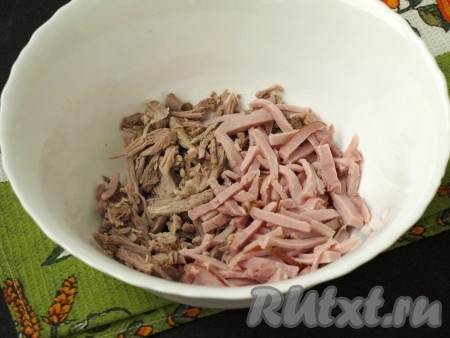 У меня для салата использовалось мясо с бёдер от домашней курицы. Нарезать мясо соломкой и разделить на волокна. Ветчину нарезать соломкой. Сложить ветчину и куриное мясо в салатник.