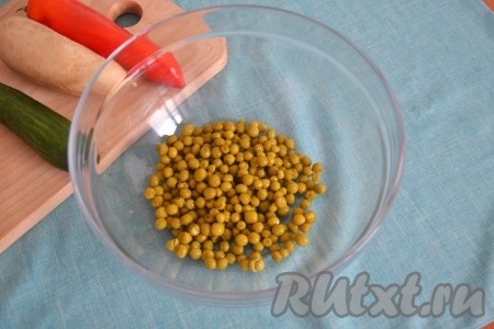 Консервированный горошек откинуть на дуршлаг, чтобы стекла вся жидкость, и выложить его в салатник.
