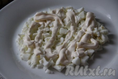 Очистить яйца, сваренные вкрутую, и разделить на желтки и белки. Белки нарезать мелкими кубиками выложить на тарелку первым слоем, смазать майонезом.