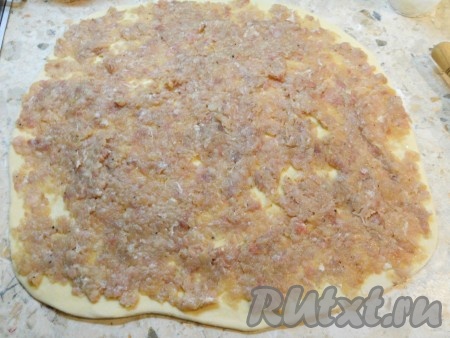 Раскатать тесто в тонкий пласт. По всему тесту размазать подготовленную мясную начинку.
