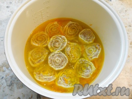 Влить теплой воды столько, чтобы она покрывала рулетики, посолить воду, всыпать сушеный чеснок, крышку мультиварки закрыть.
