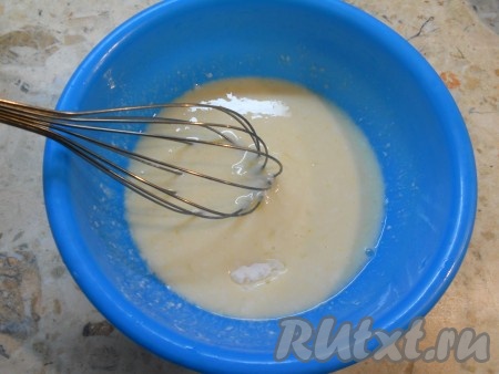 Влить кефир или кислое молоко, добавить соду и хорошенько взбить все венчиком.