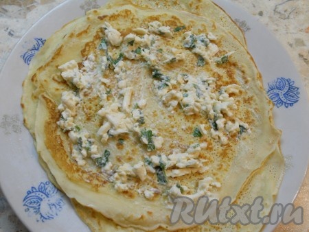 Далее теплые блинчики смазать начинкой из плавленного сыра и чеснока (не слишком густо).
