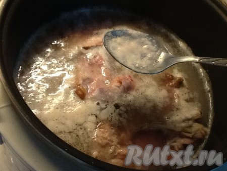 Когда горох с курицей закипят, снять пену.
