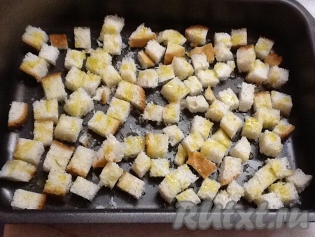 А тем временем займемся подготовкой сухариков. Включить духовку на 200 градусов. Нарезать белый хлеб на кубики, выложить на противень, сбрызнуть оливковым маслом и посыпать специями. Можно немного посыпать чесночком и посолить.