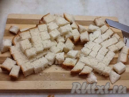 А тем временем займемся подготовкой сухариков. Включить духовку на 200 градусов. Нарезать белый хлеб на кубики, выложить на противень, сбрызнуть оливковым маслом и посыпать специями. Можно немного посыпать чесночком и посолить.