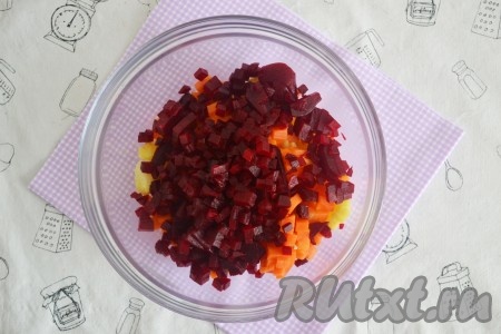 Очистить отваренную свеклу, нарезать мелкими кубиками и добавить в салат из моркови и картофеля.
