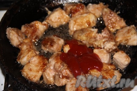 Когда свинина будет обжарена, влить в сковороду кетчуп.