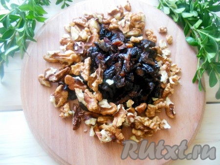 Чернослив замочите в горячей воде на несколько минут, затем обсушите и нарежьте мелкими кубиками. Очищенные грецкие орехи измельчите слегка при помощи ножа (не мелко).

