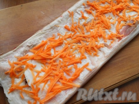 Пласт сала хорошо вымыть, поскрести шкуру, обсушить бумажными полотенцами. Разложить сало шкурой вниз. Морковь, натерев на крупной терке, выложить на сало.