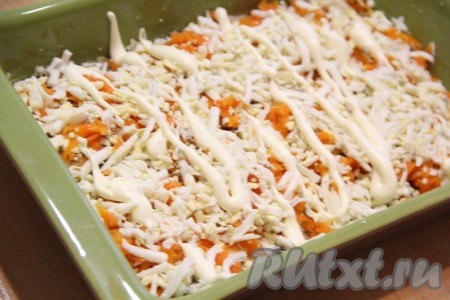 Затем поверх моркови выложить яйца, натёртые на крупной тёрке, слегка смазать майонезом и утрамбовать.