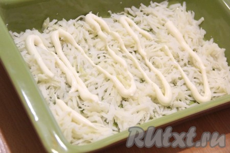 Картофель натереть на крупной тёрке, выложить на дно формы (или глубокой тарелки), немного посолить и смазать майонезом.