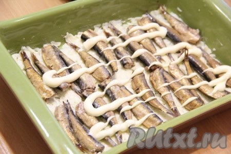 Со шпрот слить масло. Выложить шпроты на картофель в один слой, сделать решётку из майонеза.