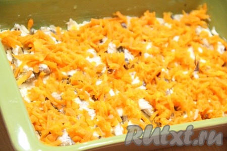 Морковь натереть на крупной тёрке и выложить поверх рыбы. 
