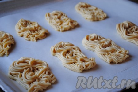 По истечении времени охлаждённое песочное тесто частями пропустить через мясорубку.&nbsp;Выходящие из решётки мясорубки полоски теста нужно придерживать одной рукой и, когда они достигнут размера 5-7 сантиметров, отрезать у решётки ножом, затем слегка прижать с одного края и выложить на противень, застеленный пергаментом, не очень плотно друг к другу. Аналогично сформировать всё печенье.
