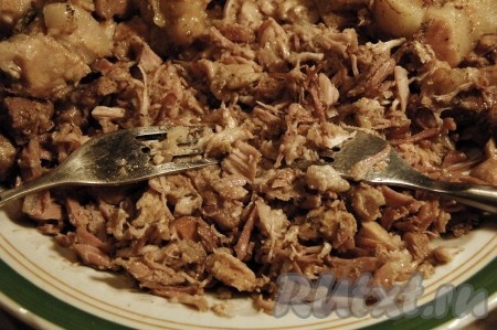 Мясо выложить на блюдо и с помощью двух вилок разобрать его на волокна.