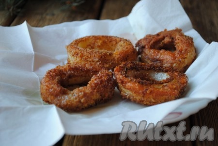Луковые кольца с сыром, приготовленные в кляре, аккуратно переложить со сковороды на бумажное полотенце, чтобы убрать лишний жир. 
