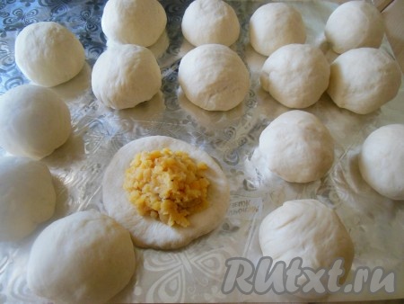 Разделите готовое тесто на равные шарики размером с мандаринку (я разделила на 20 равных частей). Раскатайте каждый шарик теста при помощи скалки, в центр положите 3-4 чайных ложки начинки. 