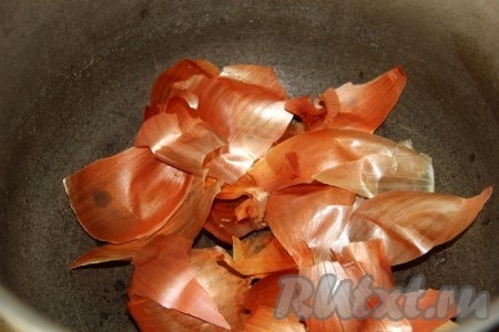 На дно казана (или толстостенной кастрюли) выложить предварительно промытую водой шелуху от лука.