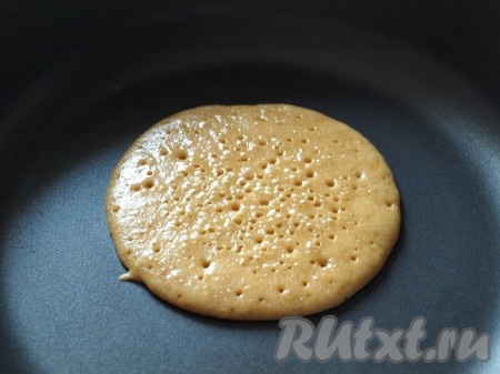 Разогреть хорошо сухую сковороду и жарить панкейки, наливая в центр по 2 столовые ложки теста. На поверхности панкейков начнут появляться маленькие дырочки.
