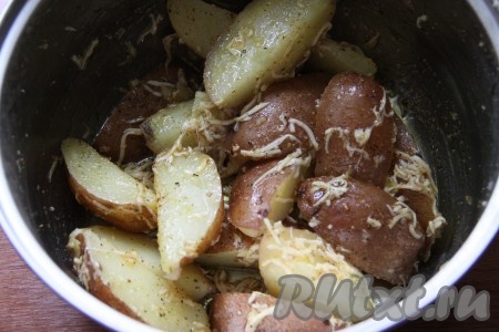 К вареным долькам картофеля добавить растительное масло со специями и натертый сыр, все аккуратно перемешать.
